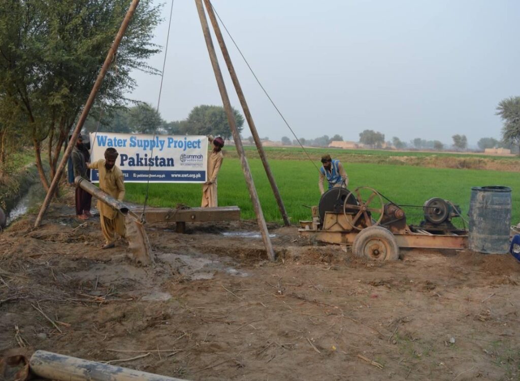 Men working on a water supply project in Pakistan, demonstrating community engagement and infrastructure development in a rural setting.